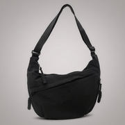 Black crescent shoulder bag with zip pockets, front product view.