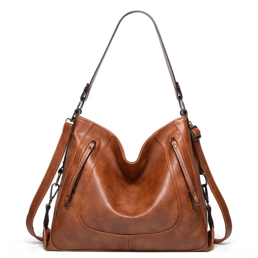 Women's handbag with a shoulder strap, a front zip and a curved outline
