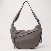 Grey crescent shoulder bag with zip pockets, front product view.