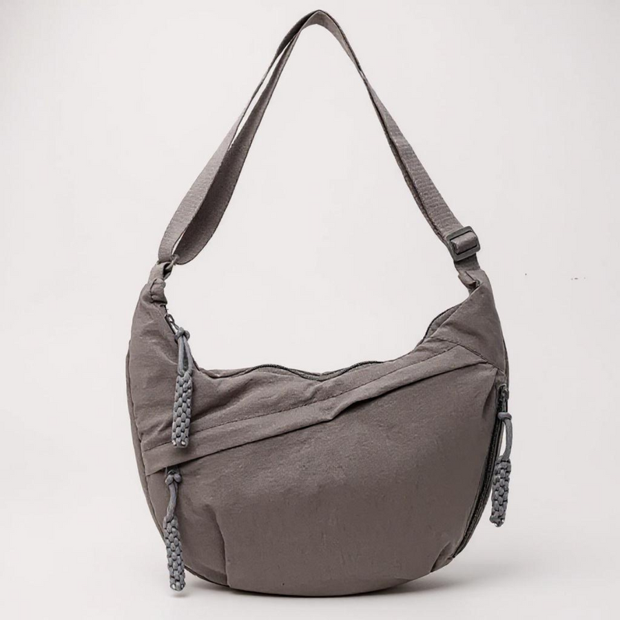 Grey crescent shoulder bag with zip pockets, front product view.