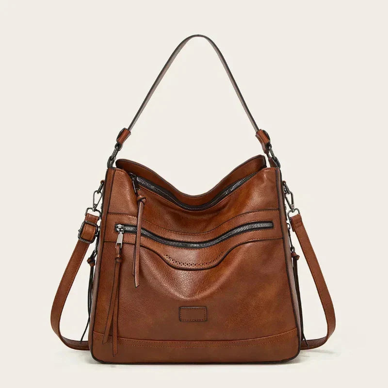 Women's handbag with a shoulder strap, a front zip and a curved outline