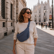 Blue crescent shoulder bag with zip pockets, bag worn across the body.