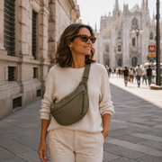 Olive green crescent shoulder bag with zip pockets, bag worn across the body.
