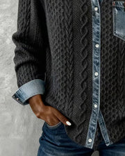 Cable-knit cardigan showing the lower button placket, contrast cuffs and curved hem.