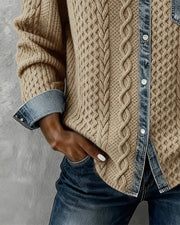 Cable-knit cardigan showing the lower button placket, contrast cuffs and curved hem.