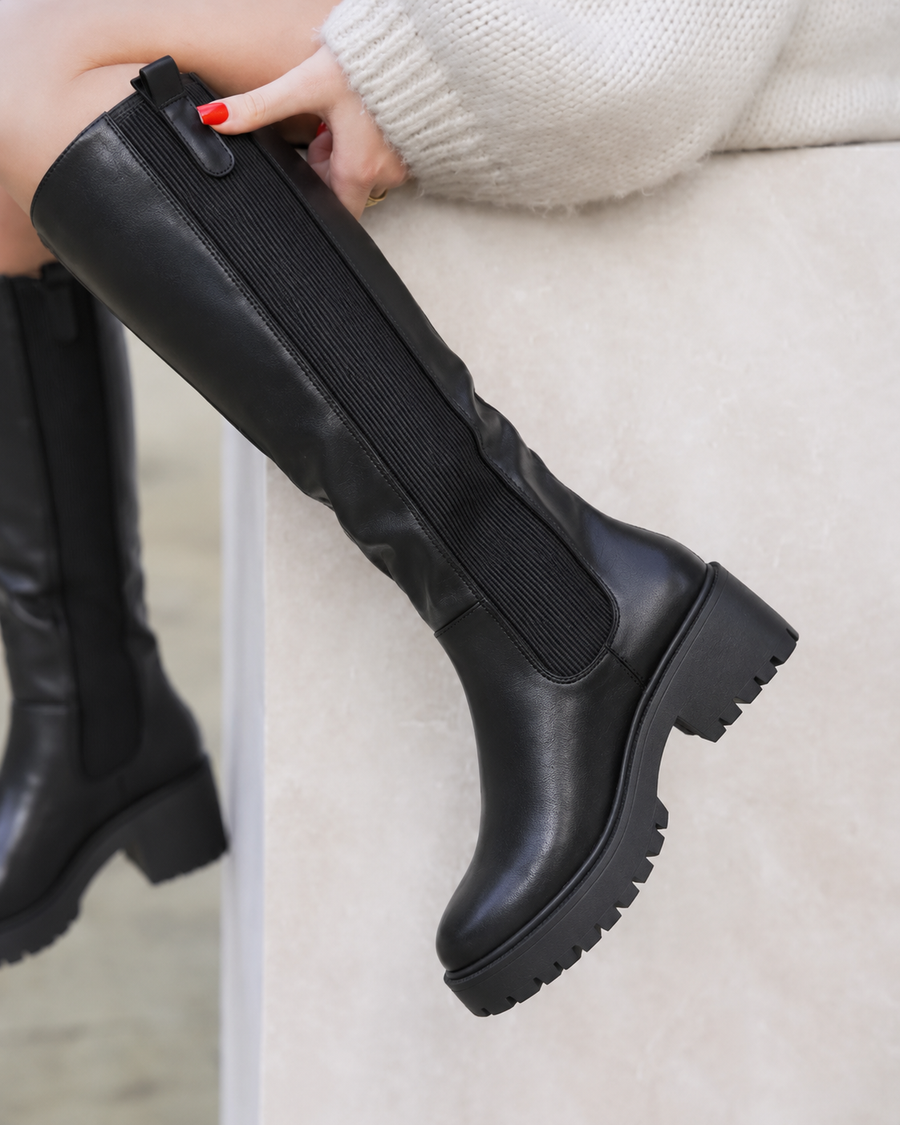 Women's knee-high boots with a chunky tread sole, an elastic side panel and a knee-high shaft