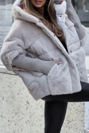 Women's gilet with a hood, contrasting surface textures and patch pockets