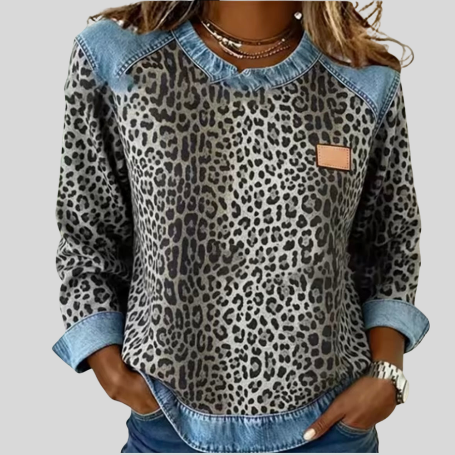 Leopard-print sweatshirt with contrast shoulder panels, a round neckline and curved hem, front view.