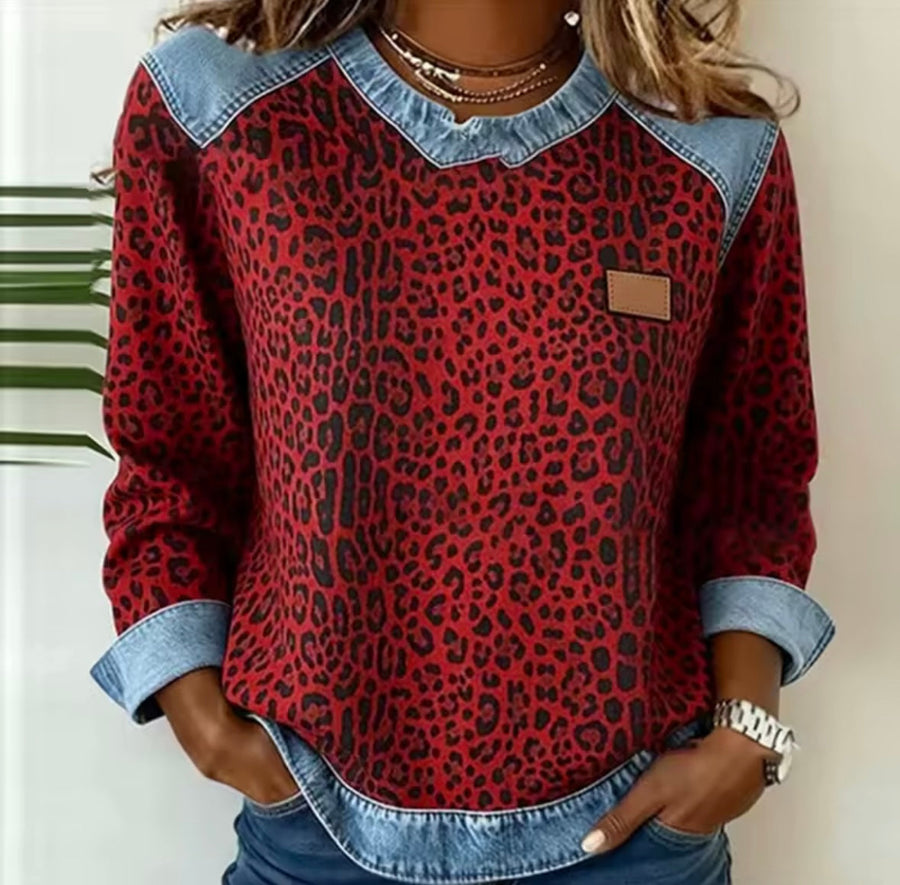 Leopard-print sweatshirt with contrast shoulder panels, a round neckline and curved hem, front view.