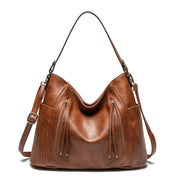 Women's handbag with a shoulder strap, a front zip and a curved outline