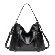 Women's handbag with a shoulder strap, a front zip and a curved outline