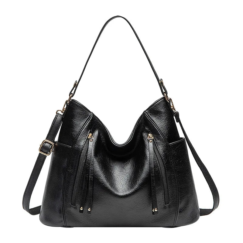 Women's handbag with a shoulder strap, a front zip and a curved outline