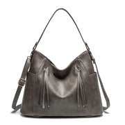 Women's handbag with a shoulder strap, a front zip and a curved outline