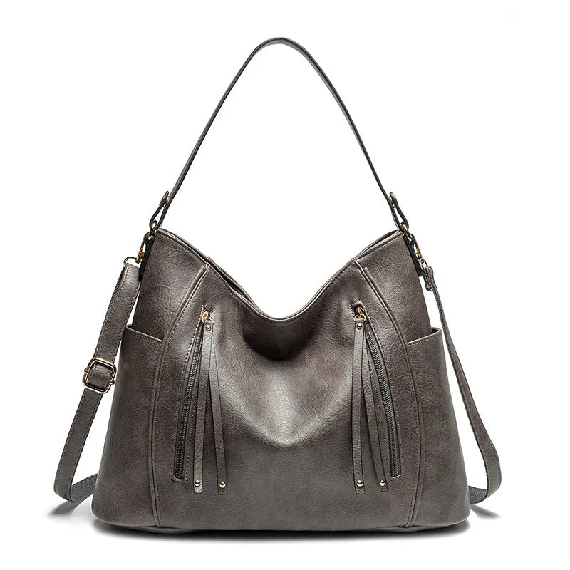 Women's handbag with a shoulder strap, a front zip and a curved outline