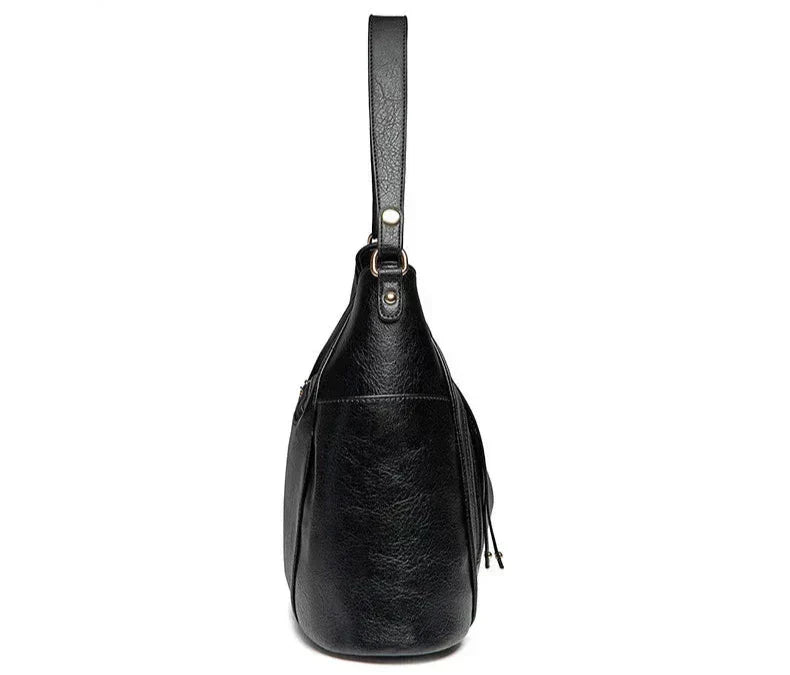 Women's handbag with a shoulder strap, a front zip and a curved outline